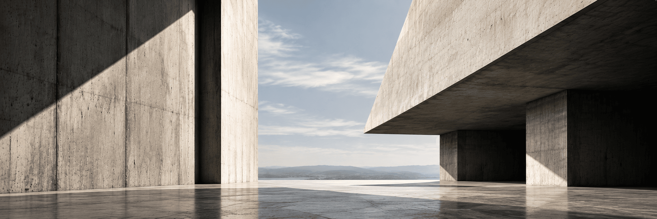 Board-marked concrete walls and a deep cantilevered slab framing a view of the sea and distant hills